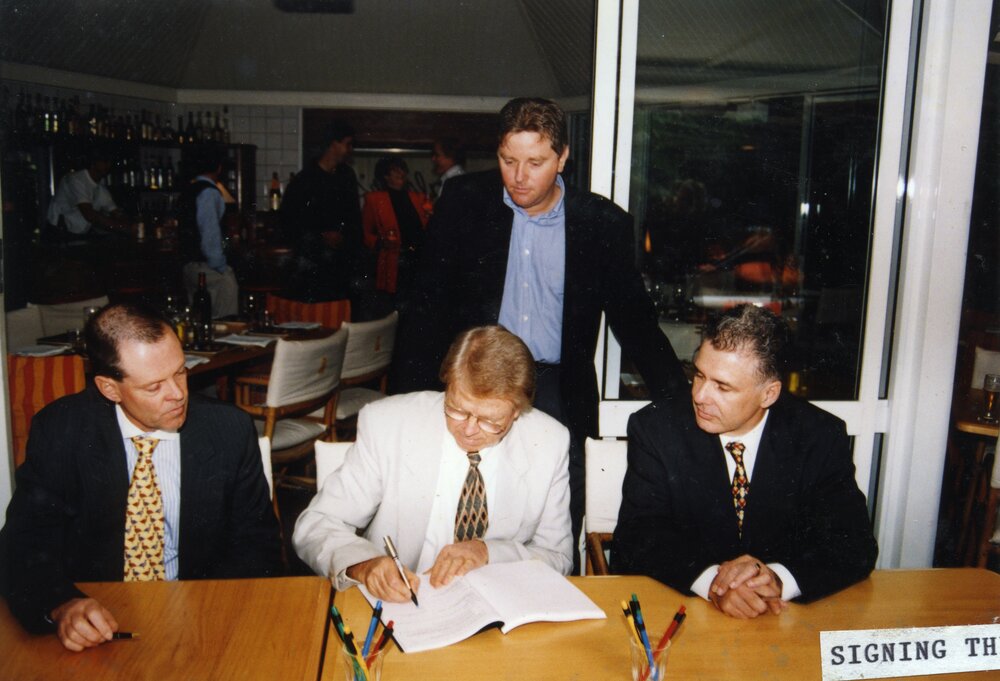 Alan Starkey (seated middle) signing development papers for Noosa Springs, ca 1992