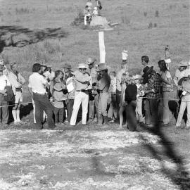Commentator and spectators, Quarter horse race, Noosa Rodeo, Weyba Ranch, Noosaville, 10 June 1973 