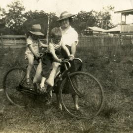 Esther Gwyder with daughter Patricia Gwyder Wood (rear of bike) (unknown child), 19 Pine Street, Pomona