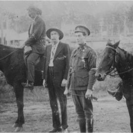 Charlie Crozier and J. Barrett (on horses), Percy Armitage Snr (standing) and Percy Armitage Jnr (in uniform), Pomona, ca 1914