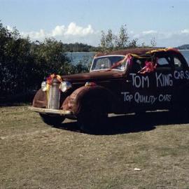 Decorated vintage car, Tom King Car Sales, Festival of Waters parade, Noosaville, 25 August 1979