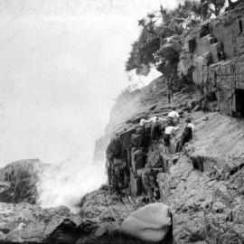 Daytrippers climbing rocks near the 'Boiling Pot' on the headland between Laguna Bay and Tea Tree Bay, Noosa Heads, 1917 