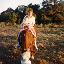 Danny Hofmann and son David, astride pet cow, Weyba Ranch, Sunset Drive, Noosa Heads, ca 1988