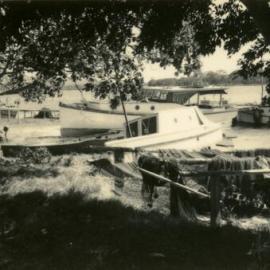 Damaged fishing boats and nets after cyclone, Noosa River, 21 February 1954